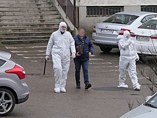 Policjanci w specjalnych kombinezonach wyprowadzili mężczyznę z budynku